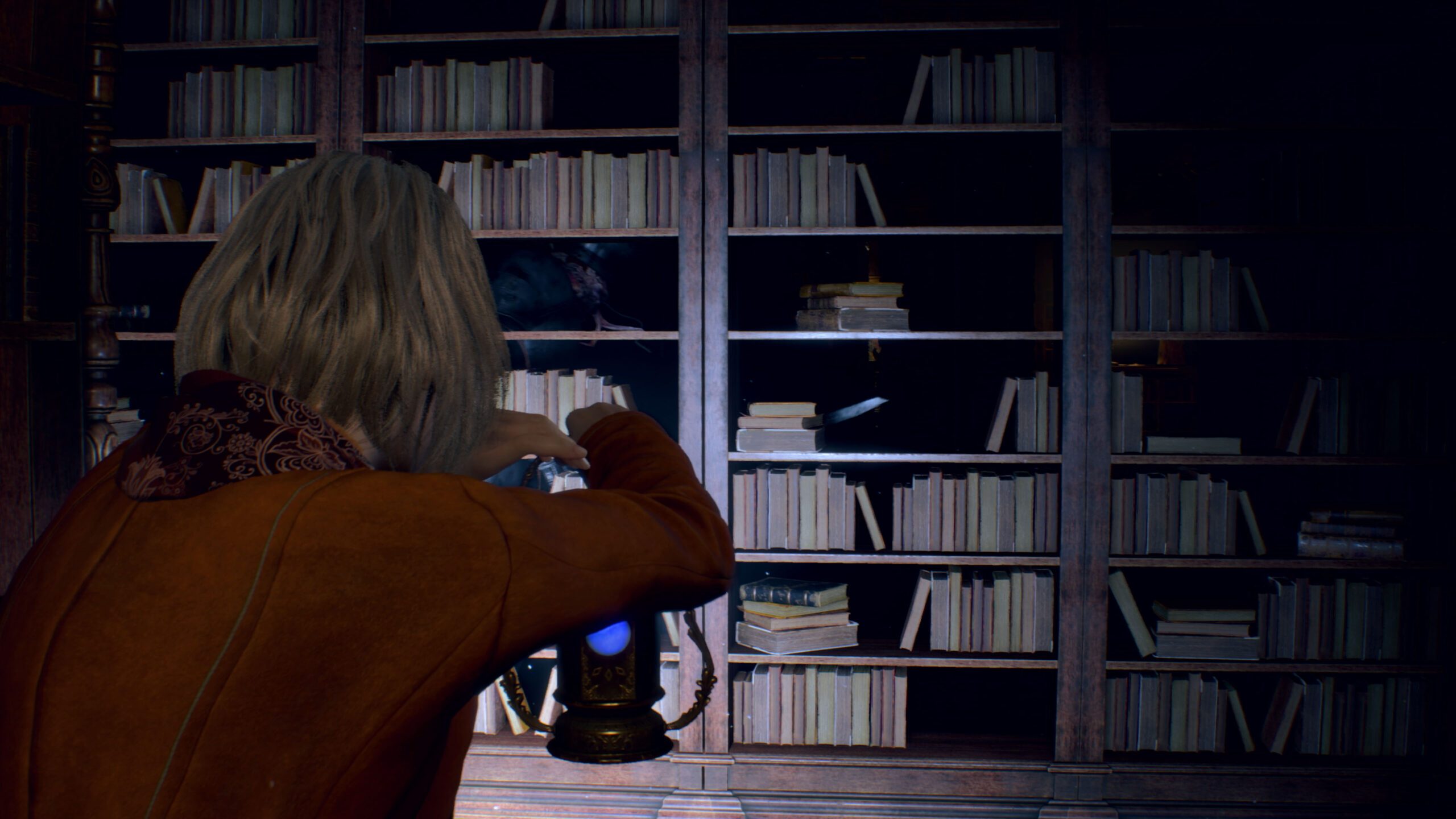 Ashley hides behind a bookcase as an ominous figure walks past on its other side.