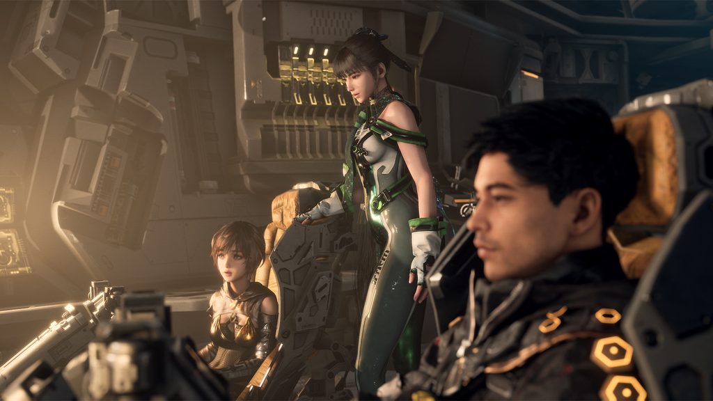 The interior of a cockpit. Eve stands between a sitting Lily and Adam.